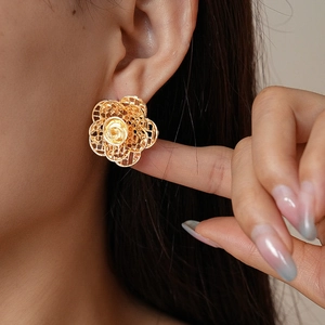 Detailansicht der goldenen zweilagigen filigranen Blumenohrringe an einem Model