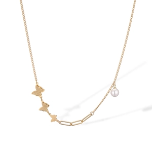 Macro detail of gold necklace featuring matte butterfly pendants and a white pearl accent