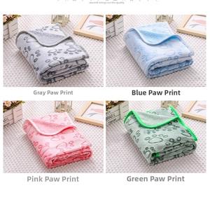 Macro detail of soft flannel pet blankets in grey, blue, pink, and green with claw patterns