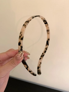 Close-up of slim tortoiseshell acrylic headband with a glossy vintage finish