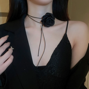Close-up of elegant handmade black fabric rose choker necklace on model neckline