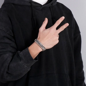 Dettaglio di un bracciale a catena vintage color argento indossato con stile streetwear casual