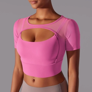 Detail of hot pink crop top featuring mesh splicing and cutout design for yoga and fitness