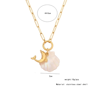 Detailed view of a golden dolphin and white shell pendant on a stainless steel necklace