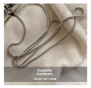 Macro shot of high-quality silver metallic snake chain strap on soft velvet fabric