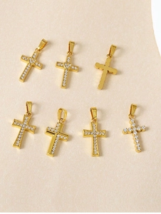 Macro detail of seven assorted gold-plated cross pendants with cubic zirconia inlay