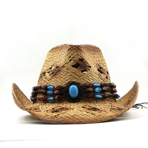 Detail of woven straw cowboy hat featuring a turquoise beaded band and ethnic stone