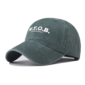Close-up of embroidered M.Y.O.B. lettering on washed cotton baseball cap texture