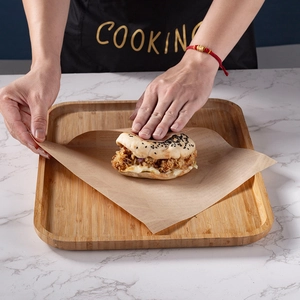 Brown oil-proof sandwich wrapping paper for fried chicken on a wooden tray