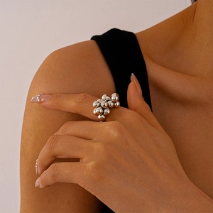 Close-up of a silver pleated irregular sphere ring worn on a finger with a modern style
