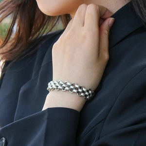 Close-up of a chunky silver stainless steel chain bracelet with industrial retro metal finish