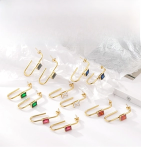 Detailed view of U-shaped gold earrings with colorful rectangular zircon gemstones
