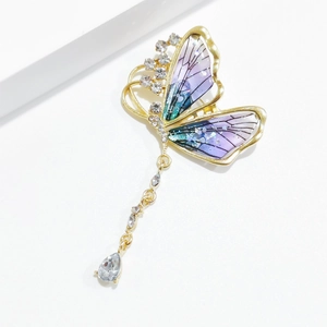 Detail of vintage butterfly brooch with purple gradient wings and dangling crystals