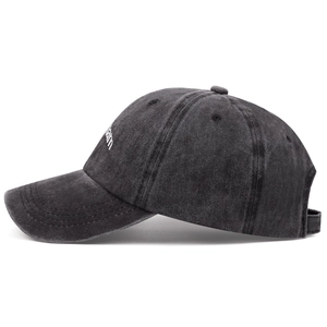 Close-up of side white embroidery and washed gray cotton fabric on baseball cap