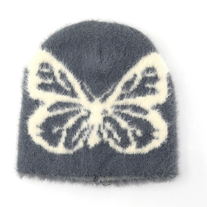 Detail of dark grey knit beanie featuring a white butterfly pattern and plush texture