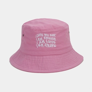 Close-up of pink cotton bucket hat featuring white embroidered positive quotes and eyelets
