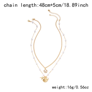 Detail view of gold layered necklace with pearl starfish and shell charm measurements