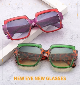 Close-up of oversized square sunglasses with color blocking and glittery translucent frames
