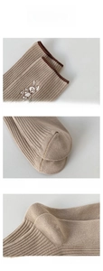 Detail view of khaki cotton socks showing elastic cuff with rabbit embroidery and reinforced toe