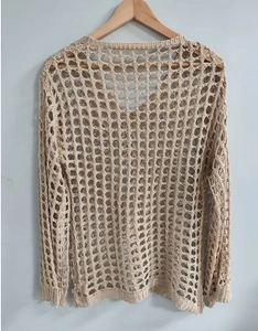 Détail du motif en maille crochet ajourée sur un haut de plage beige à manches longues