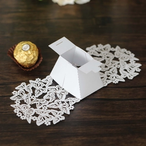 Detailed view of a white wedding favor box with an intricate hollow butterfly design