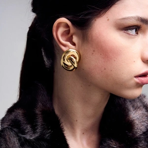 Modern 18k gold plated double ring twisted hoop earrings worn by a model in luxury style