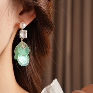 Detail von eleganten Silbernadel-Ohrringen mit mintgrünen Muschelblättern und Zirkonia