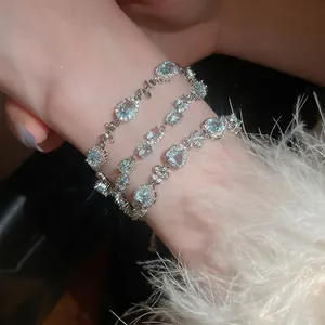 Elegant silver bracelet set with light blue oval zircon stones and sparkling heart charms