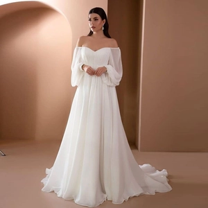 Off-shoulder long sleeve white wedding dress with puff sleeves and elegant flowing skirt