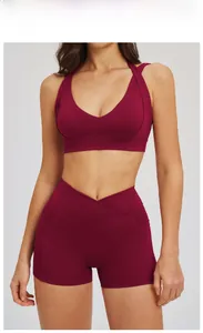 Dettaglio degli shorts da yoga rosso ciliegia con vita a V incrociata e tasche laterali