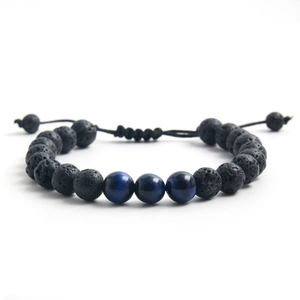 Adjustable tiger eye and black volcanic stone braided bracelet on a white background