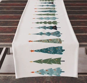 Detailed top view of linen Christmas table runner with festive colorful tree patterns