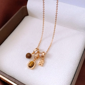 Detail of tiger eye stone beads and gold-plated quilted metal pendant on vintage necklace