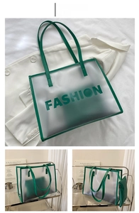 Detail of green transparent tote bag with fashion lettering and matching inner pouch