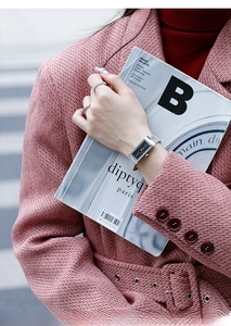 Silver rectangular quartz watch with mesh band worn with stylish pink textured coat