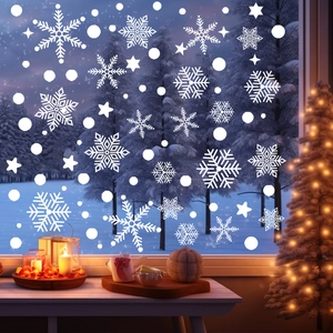 Detailed view of white snowflake and star static window clings on glass with a cozy background