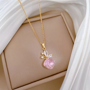 Detail of gold butterfly necklace with a pink square crystal on soft white silk