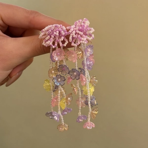 Detailed view of handmade colorful beaded flower tassel earrings with vibrant petals