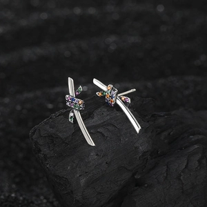 Macro shot of silver rope earrings with multi-color zircon stones on black background