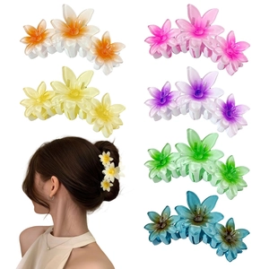 Detail view of colorful matte flower hair claws in six colors with a model wearing example