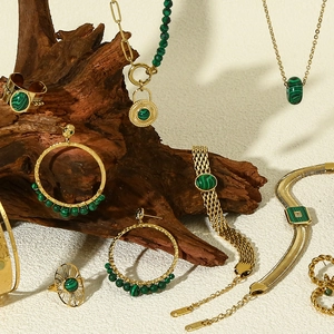 Detailed view of 18k gold plated jewelry set with green malachite on natural wood