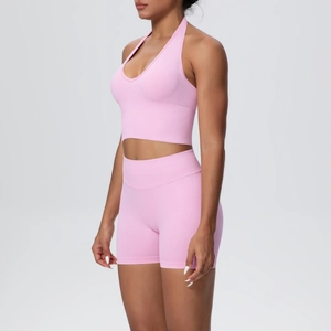 Detailed side view of pink seamless ribbed yoga set featuring halter bra and high-waist shorts