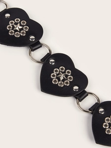 Close-up of black heart leather belt with metal rings, stars, and punk rivets
