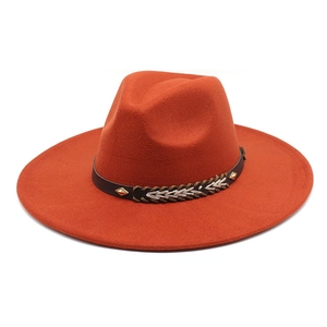 Detail of rust orange fedora hat featuring brown leather band with gold rivets