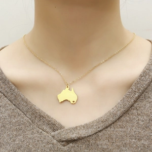 Close-up of gold Australian map necklace with heart cutout detail on model's neck