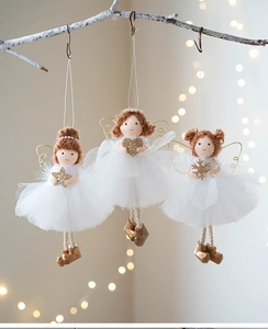 Three plush Christmas angel ornaments with white tulle dresses hanging on a rustic branch