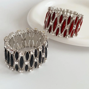 Dettaglio di bracciali vintage elastici con pietre marquise nere e rosse su base argento