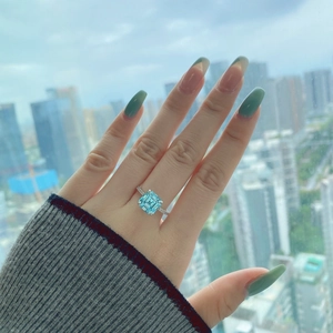 Detail of S925 silver ring featuring a blue square zircon worn on a hand with green nails