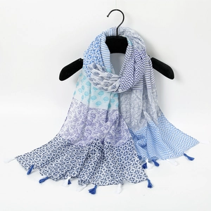 Detail of blue and white printed scarf with tassel fringe and mixed geometric patterns