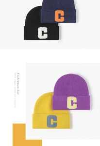 Détail de quatre bonnets en maille colorés avec broderie bouclée texturée du logo lettre C